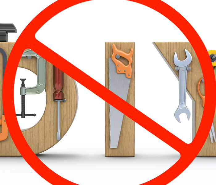 An illustration of verious tools around a wooden DIY sign, with a cross out circle superimposed.