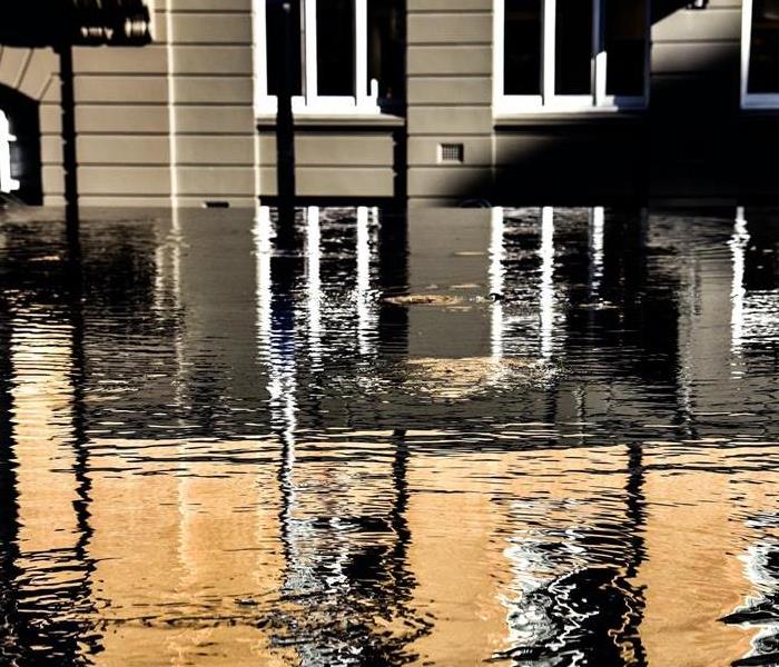 Water rises in an urban environment, covering the subfloor of a commercial building.