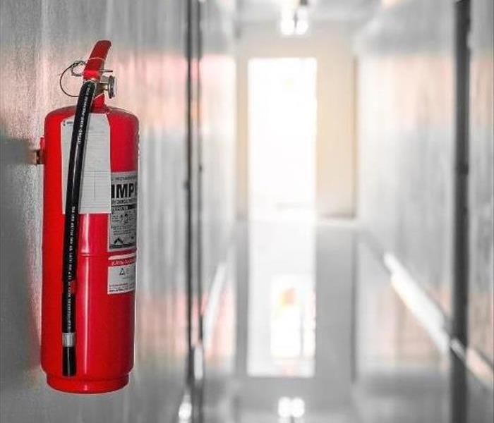 Fire extinguisher mounted to a hallway wall.