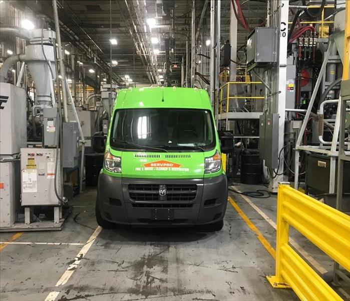 Green SERVPRO service van inside a factory