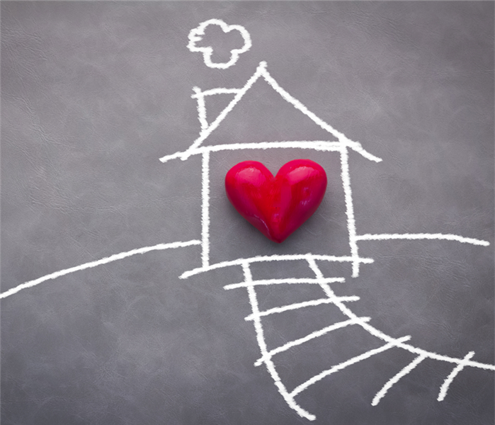 Chalkboard drawing of a house that includes a red heart within the house.